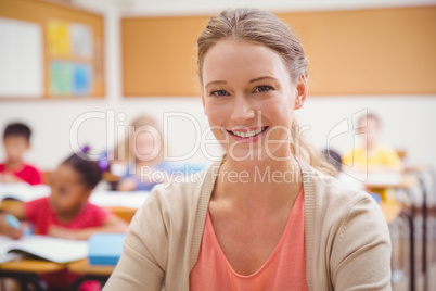 Pretty teacher smiling at camera at top of classroom Pretty teacher smiling at camera at top of classroom