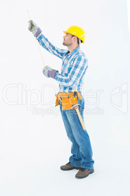 Construction worker using measure tape