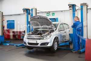 Mechanic raising the car with a workshop jack