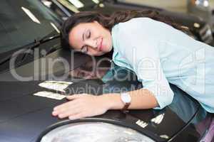 Smiling woman hugging a black car