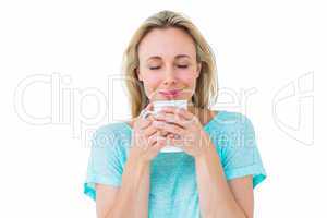 Cheerful blonde holding mug of hot drinking