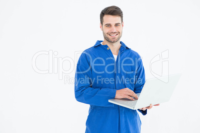 Happy young male mechanic using laptop