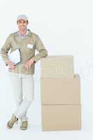 Smiling delivery man standing by stack of boxes