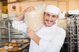 Smiling baker holding bag of rising dough