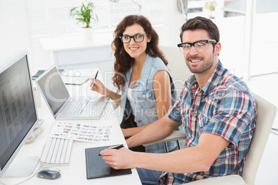 Smiling businessman using laptop and digitizer