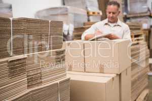 Warehouse worker checking his list on clipboard