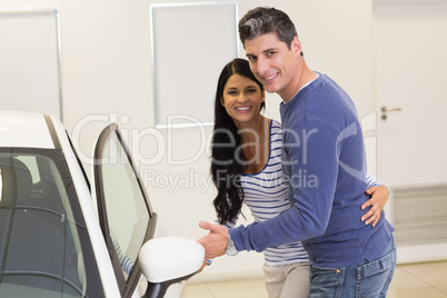 Couple holding a car door handles