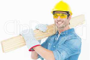 Carpenter wearing hardhat and glasses while carrying wooden plan