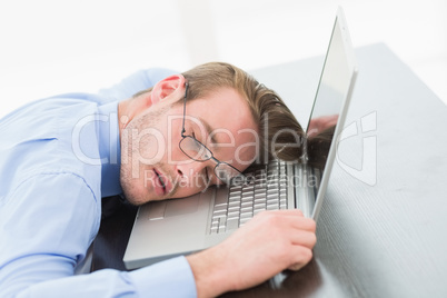 Businessman with glasses sleeping on laptop