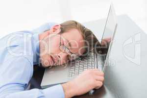 Businessman with glasses sleeping on laptop