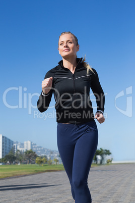 Fit blonde jogging on the pier