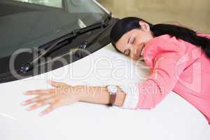 Smiling woman hugging a white car