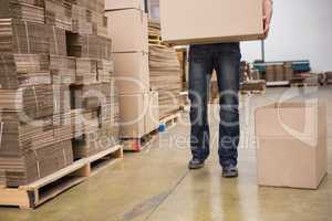 Worker with box in warehouse