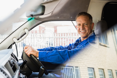 Smiling delivery man driving his van