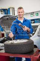 Smiling mechanic inflating the tire