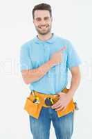 Happy carpenter pointing against white background