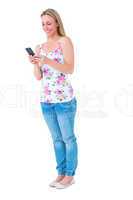 Smiling blonde sending a text message