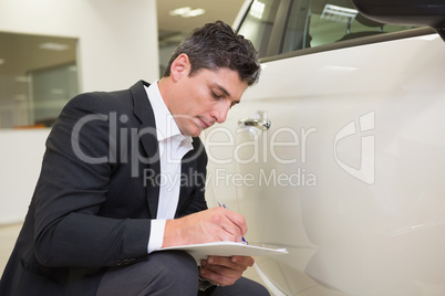 Focused businessman looking at the car body