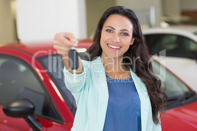 Female driver showing a key after bying a new car