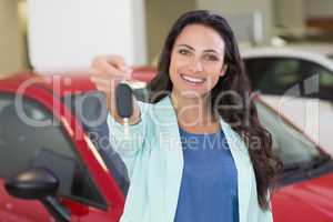 Female driver showing a key after bying a new car