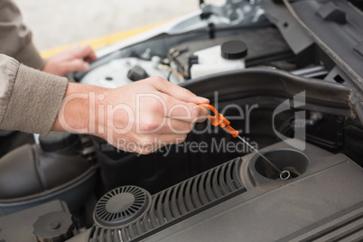 Man using dipstick to check oil