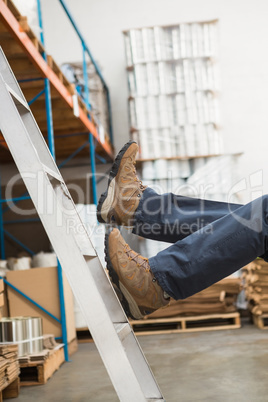 Worker falling off ladder in warehouse