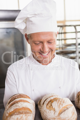 Happy baker showing tray of fresh bread