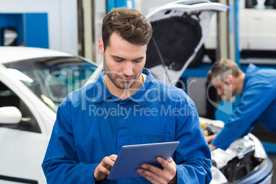 Smiling mechanic using a tablet pc