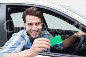 Young man smiling at camera showing card