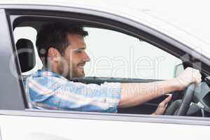 Young man driving and smiling