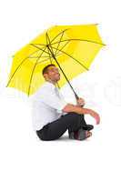 Businessman sitting on the floor with yellow umbrella