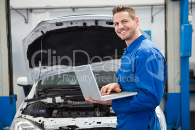 Mechanic typing on a laptop