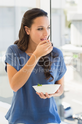 Pretty brunette eating a salad