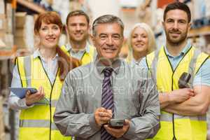 Smiling warehouse team with arms crossed