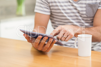 Young man using tablet while having coffee