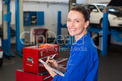 Mechanic writing on a clipboard