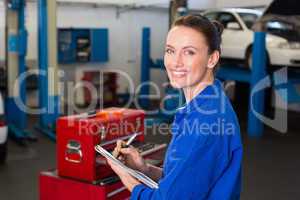 Mechanic writing on a clipboard