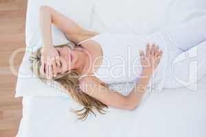 Blonde woman lying suffering from stomach pain