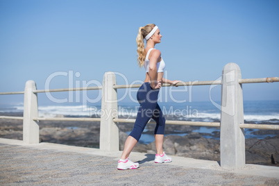 Fit woman stretching on the pier