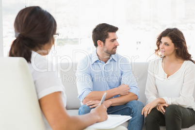 Couple sitting on sofa talking with their therapist