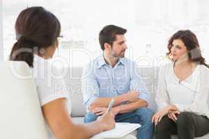 Couple sitting on sofa talking with their therapist