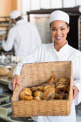 Pretty baker showing basket of bread