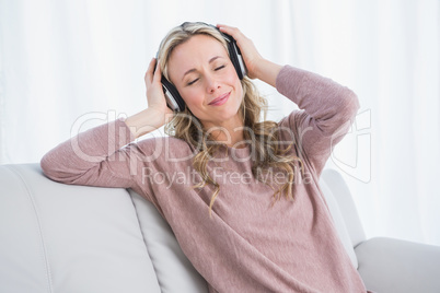 Smiling blonde eyes closed enjoying and listening music