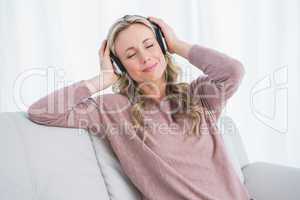 Smiling blonde eyes closed enjoying and listening music