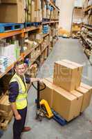 Worker with trolley of boxes smiling at camera