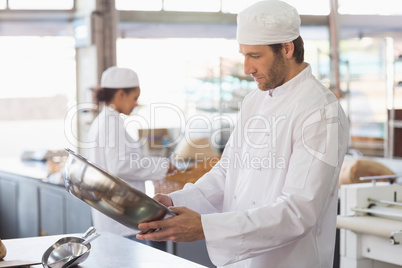 Baker looking in mixing bowl