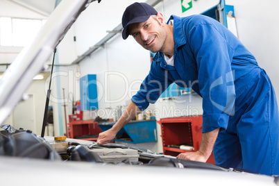 Mechanic examining under hood of car