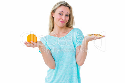 Pretty blonde holding slice of pizza and orange