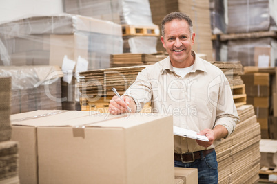 Warehouse worker checking his list on clipboard