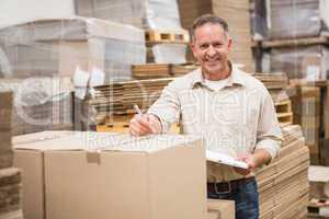 Warehouse worker checking his list on clipboard